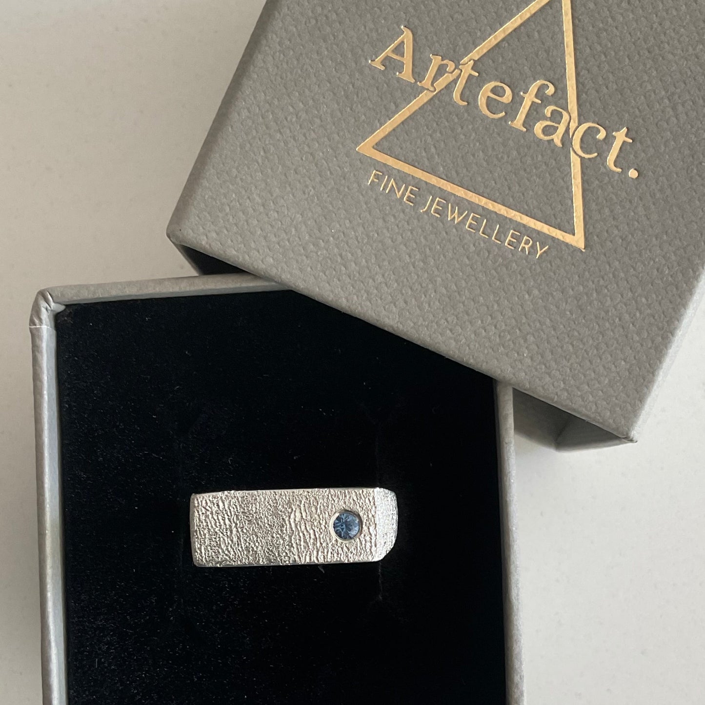 Silver signet ring with a sapphire \ in a 'Artefact' box
