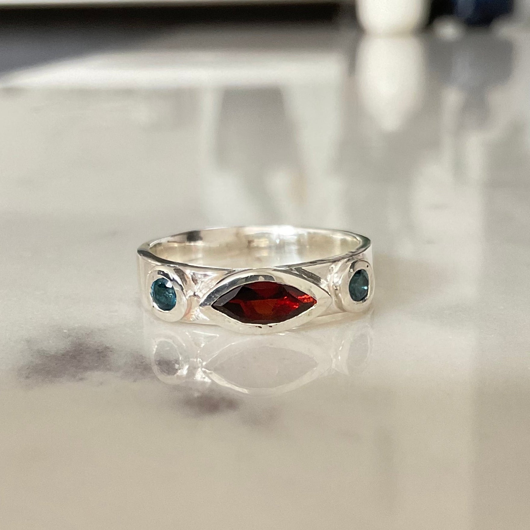 Sterling silver ring bezel set with garnet and london blue topaz gemstones