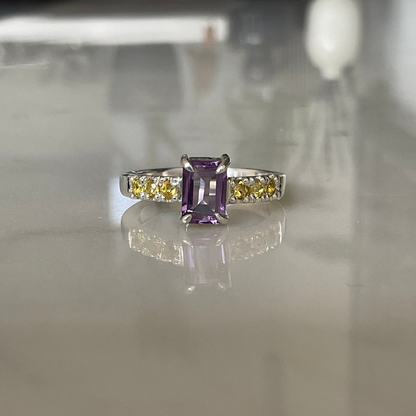 Amethyst ring claw set with yellow sapphires set into the ring band.