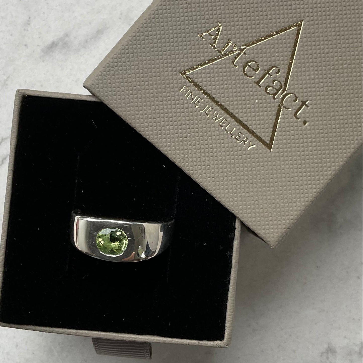 Sterling silver and green tourmaline man’s ring shown in ring box