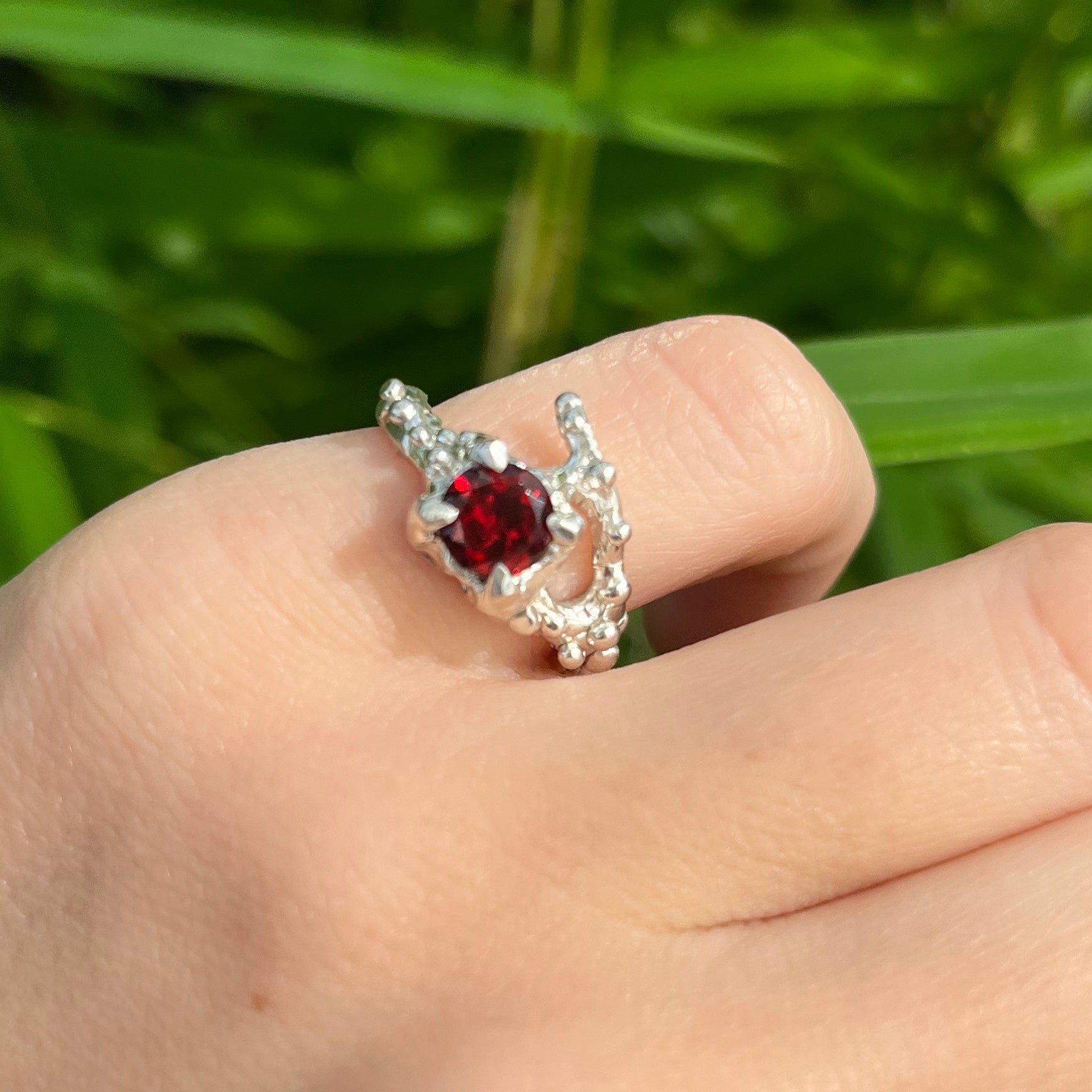 silver garnet ring shown on model