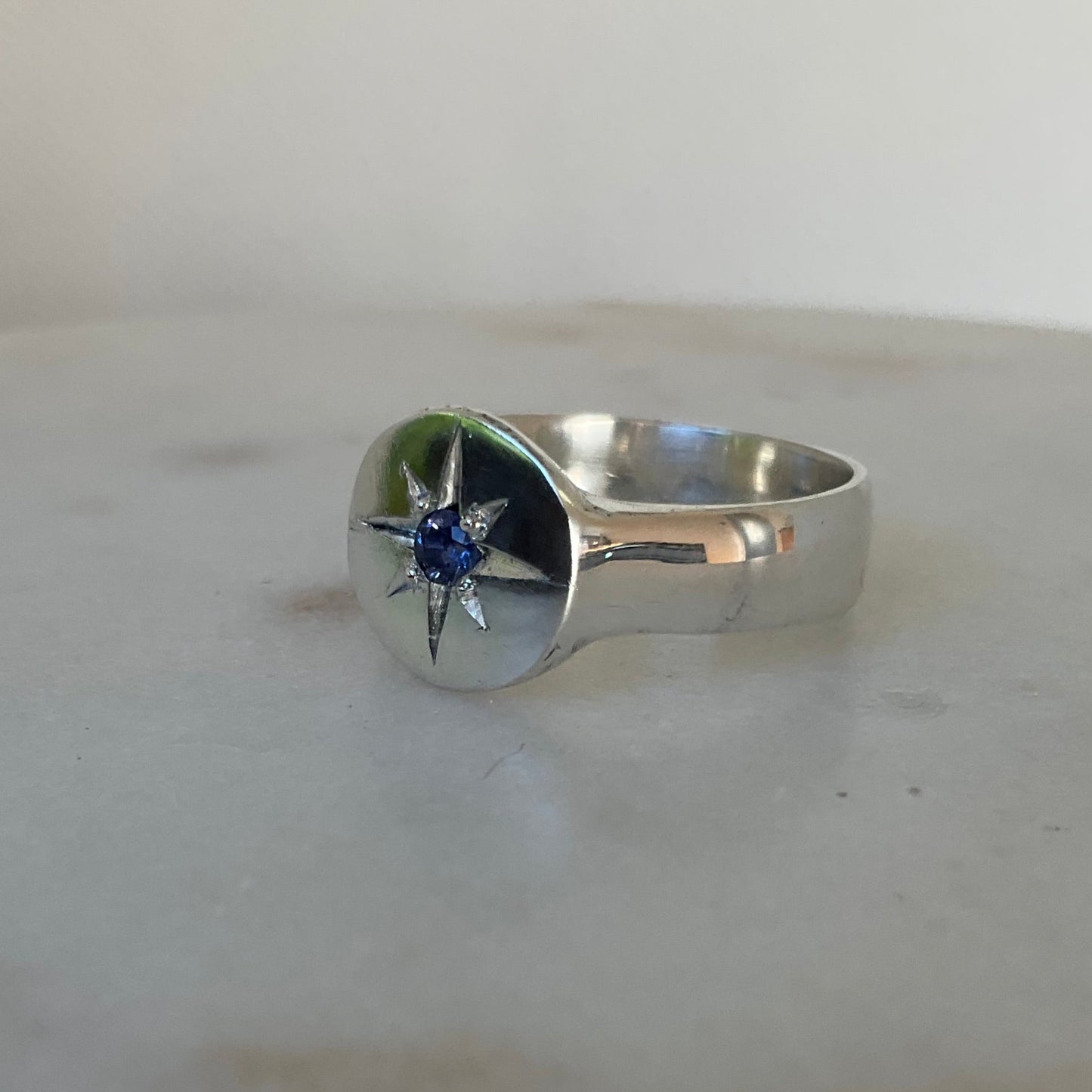 Side view of star set sapphire silver signet ring