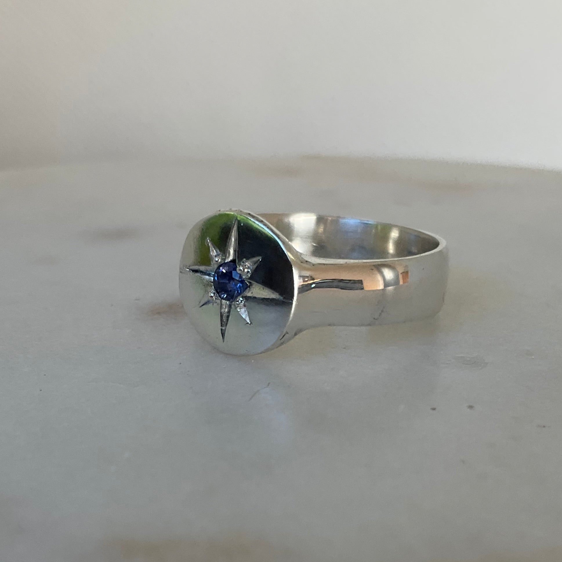 Side view of star set sapphire silver signet ring