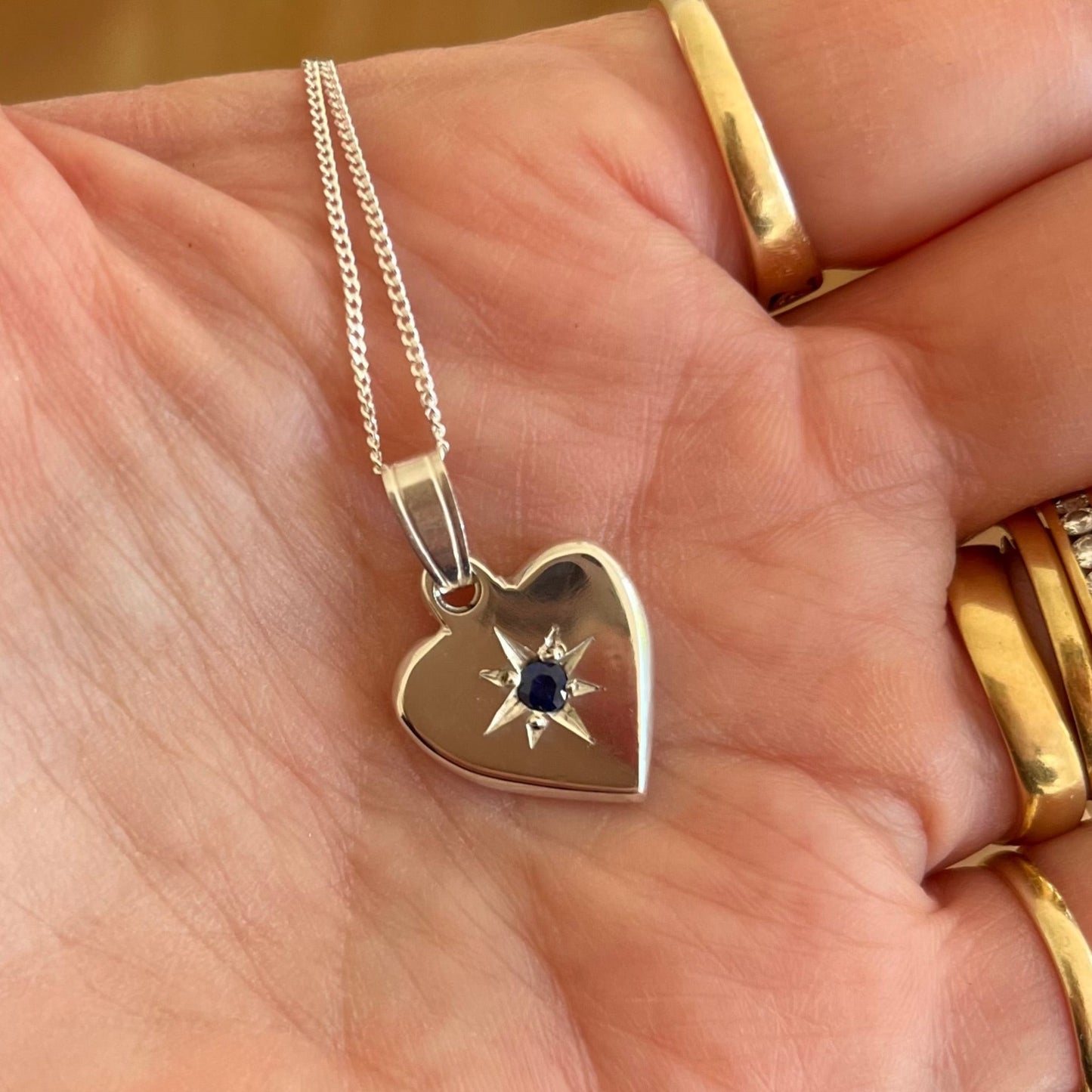 Heart shaped pendant set with a blue sapphire