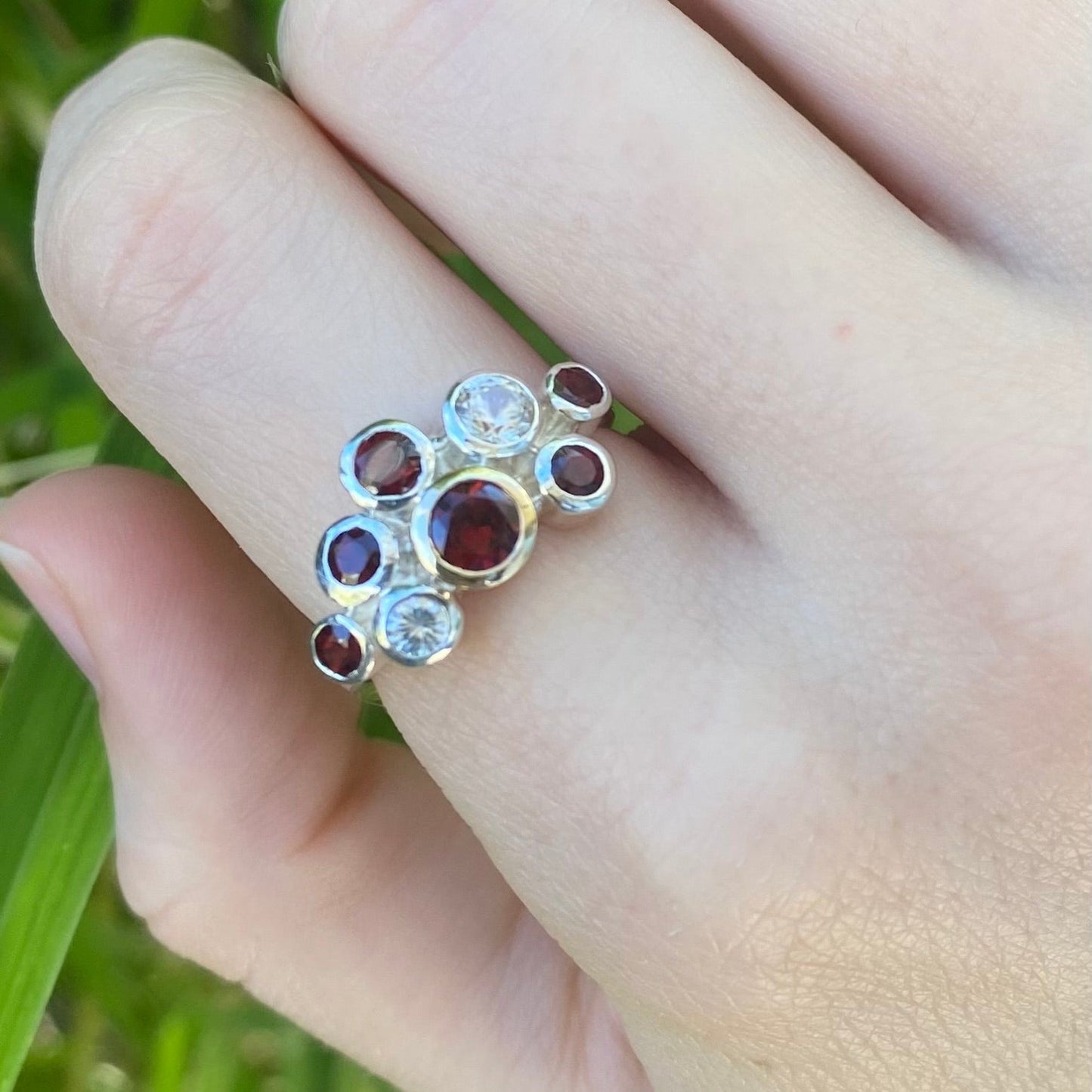 Garnet and Zircon cluster ring shown on hand