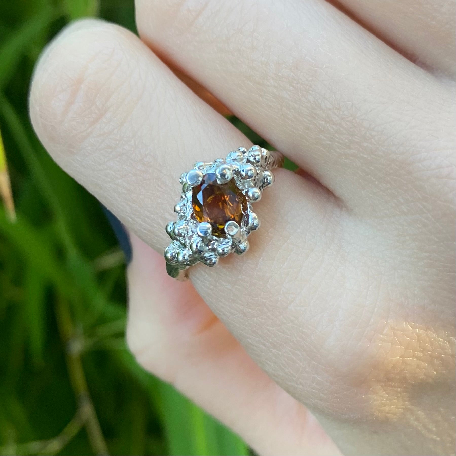 Orange tourmaline ring shown on hand