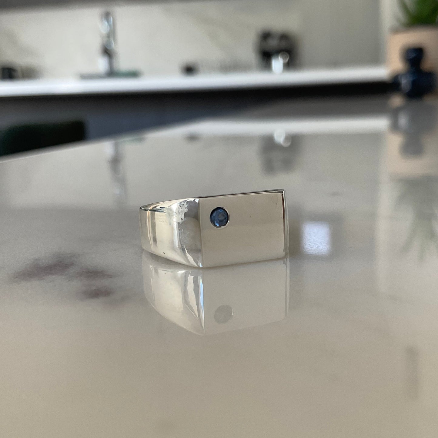Silver signet ring flush set with a 2.5mm blue sapphire handmade in Melbourne