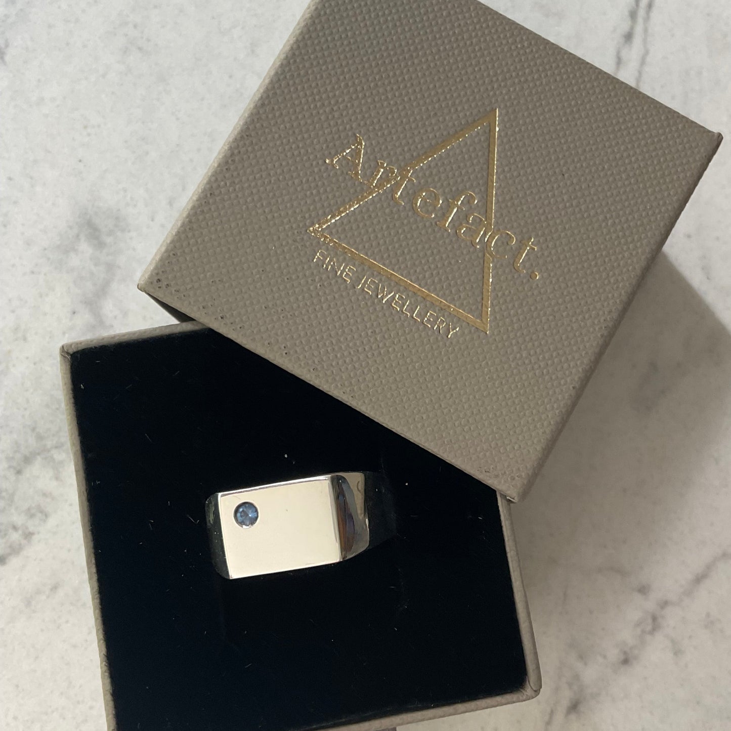 Silver signet ring shown in ring box