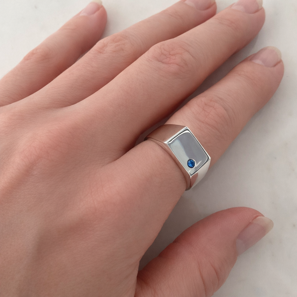 Silver signet ring shown on hand