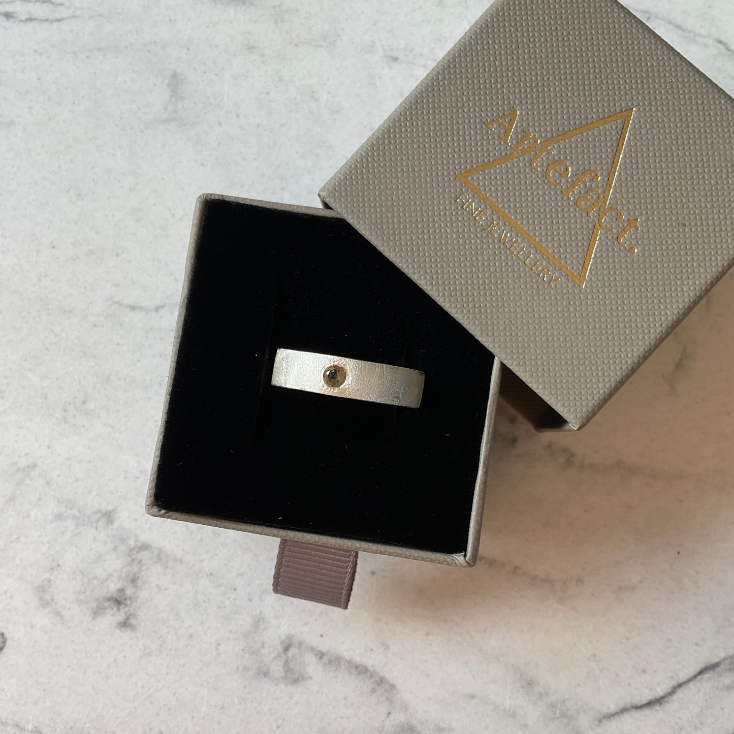 Custom flush set gold tourmaline in a textured ring band.