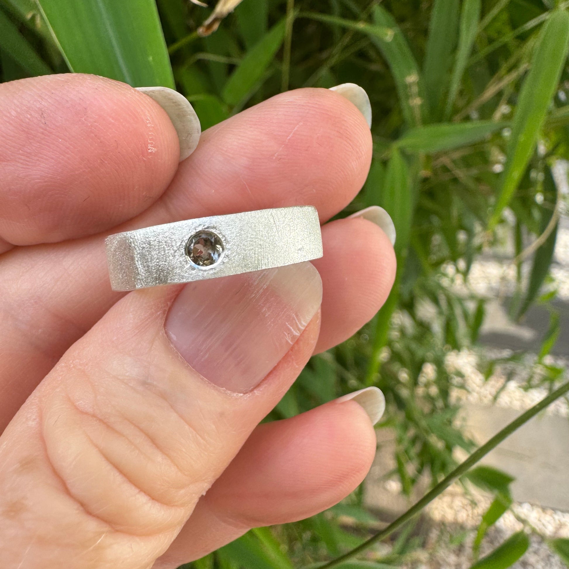 Flush set tourmaline in a brushed silver ring band
