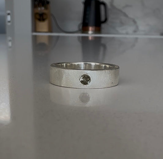 Custom flush set gold tourmaline in a textured ring band.