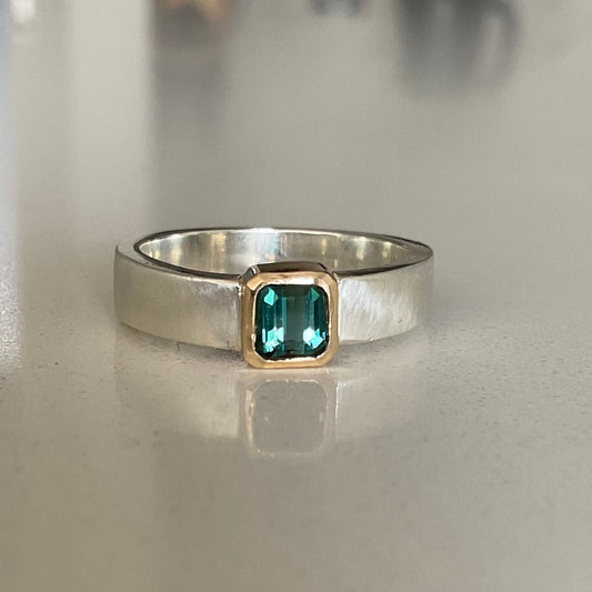 Green tourmaline gemstone set in a solid 9ct gold setting in a brushed silver ring band.