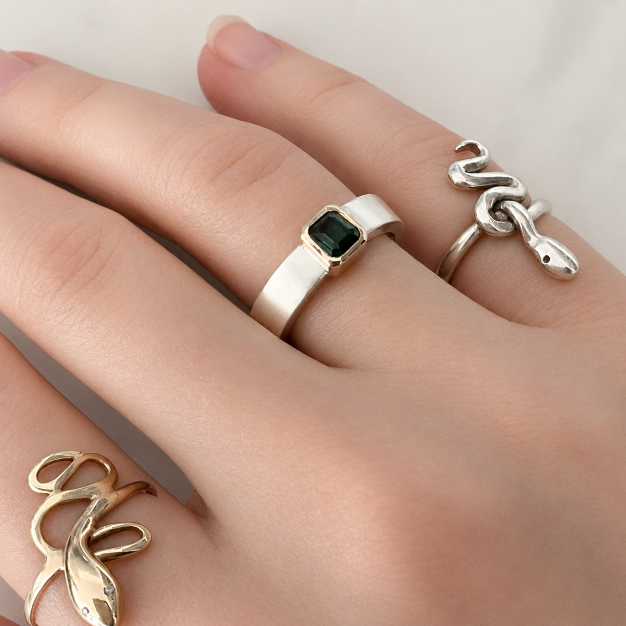 Green tourmaline gemstone “Forest ring” styled on a hand with other rings.