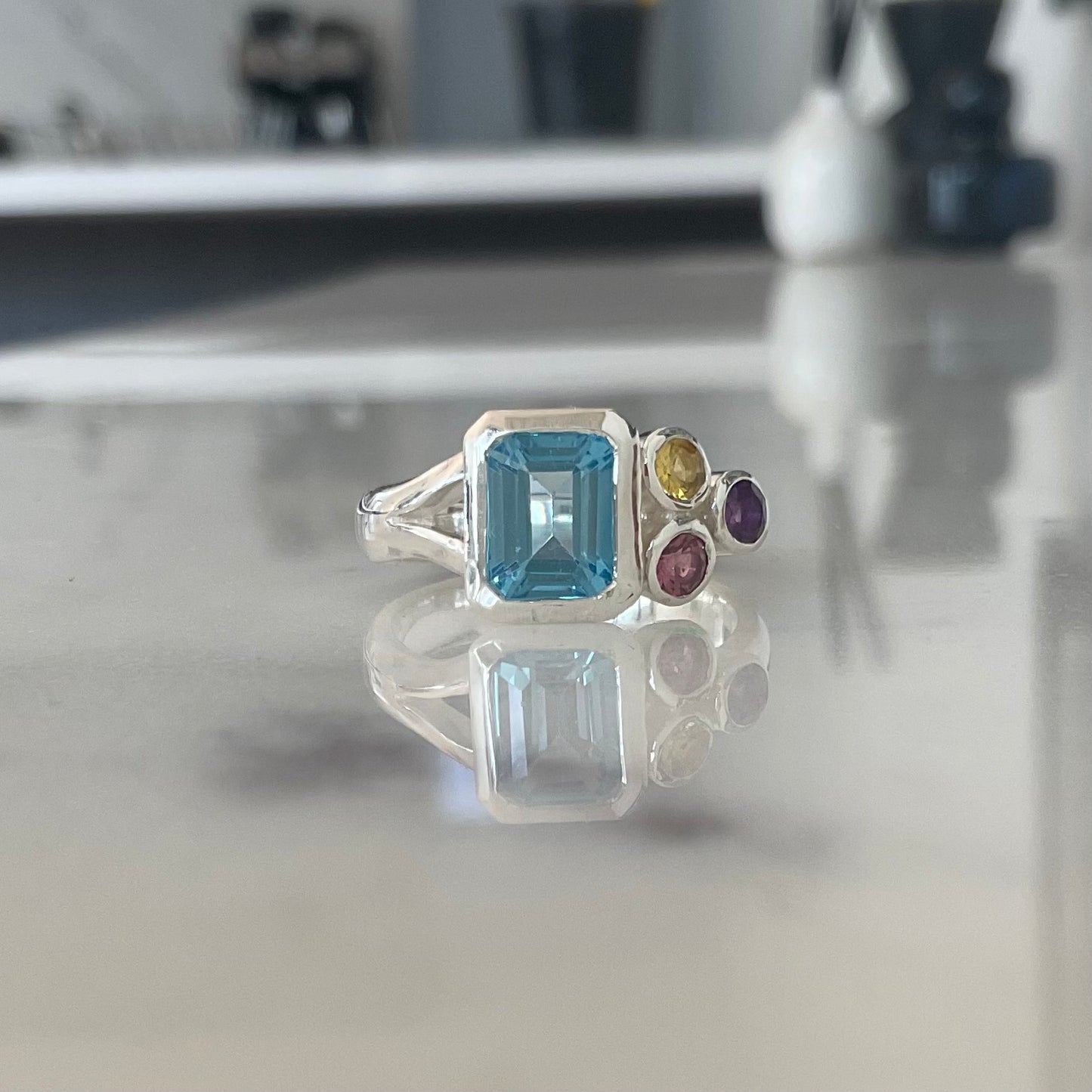 Blue topaz cluster ring with silver ring band and accent stones.