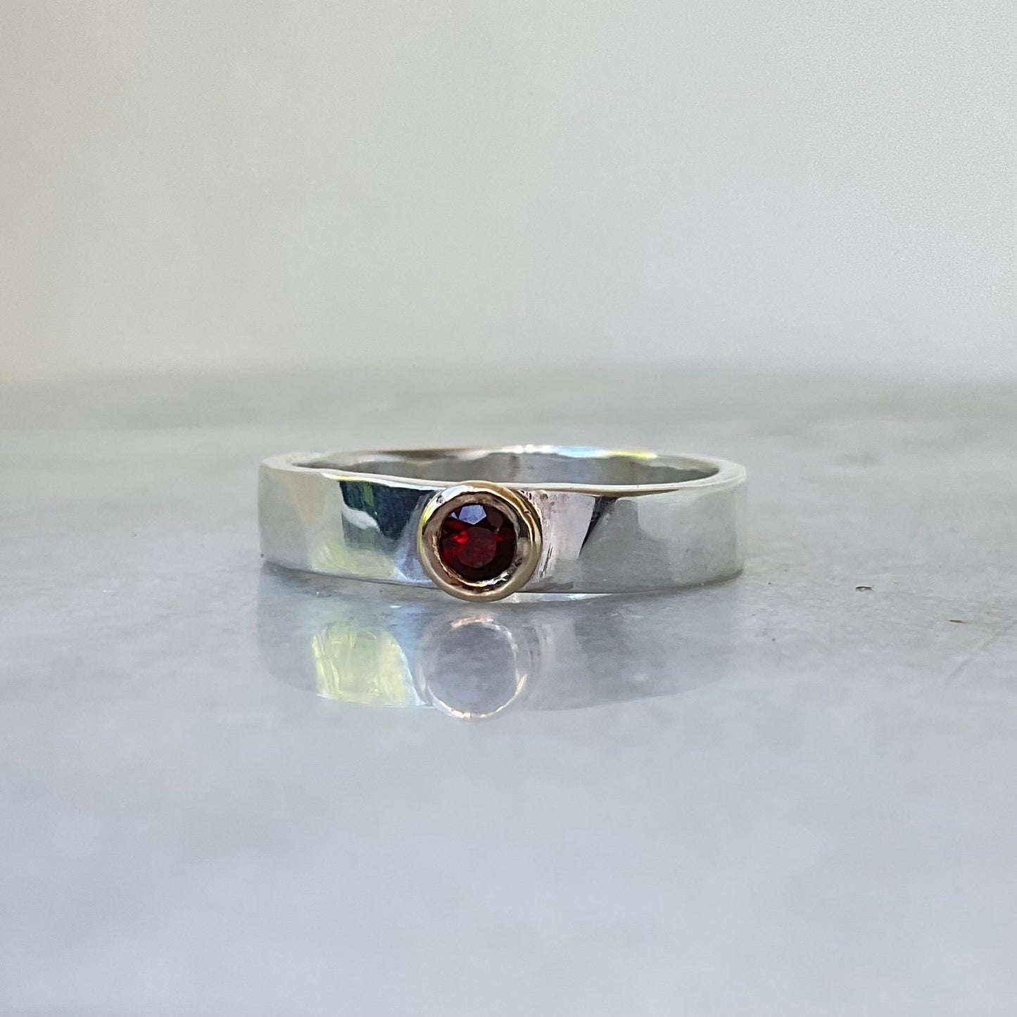 Garnet set in 9ct gold on a silver band