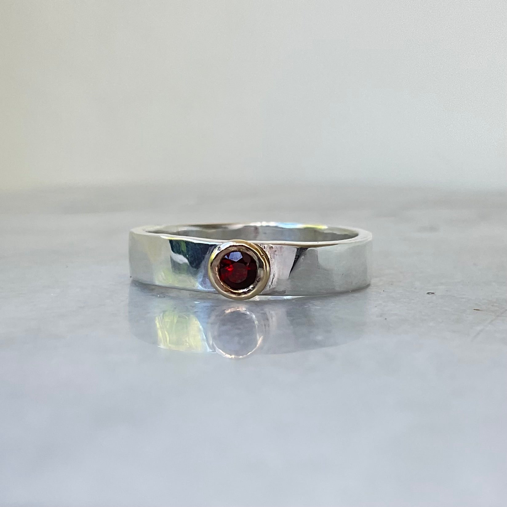 Garnet set in 9ct gold on a silver band