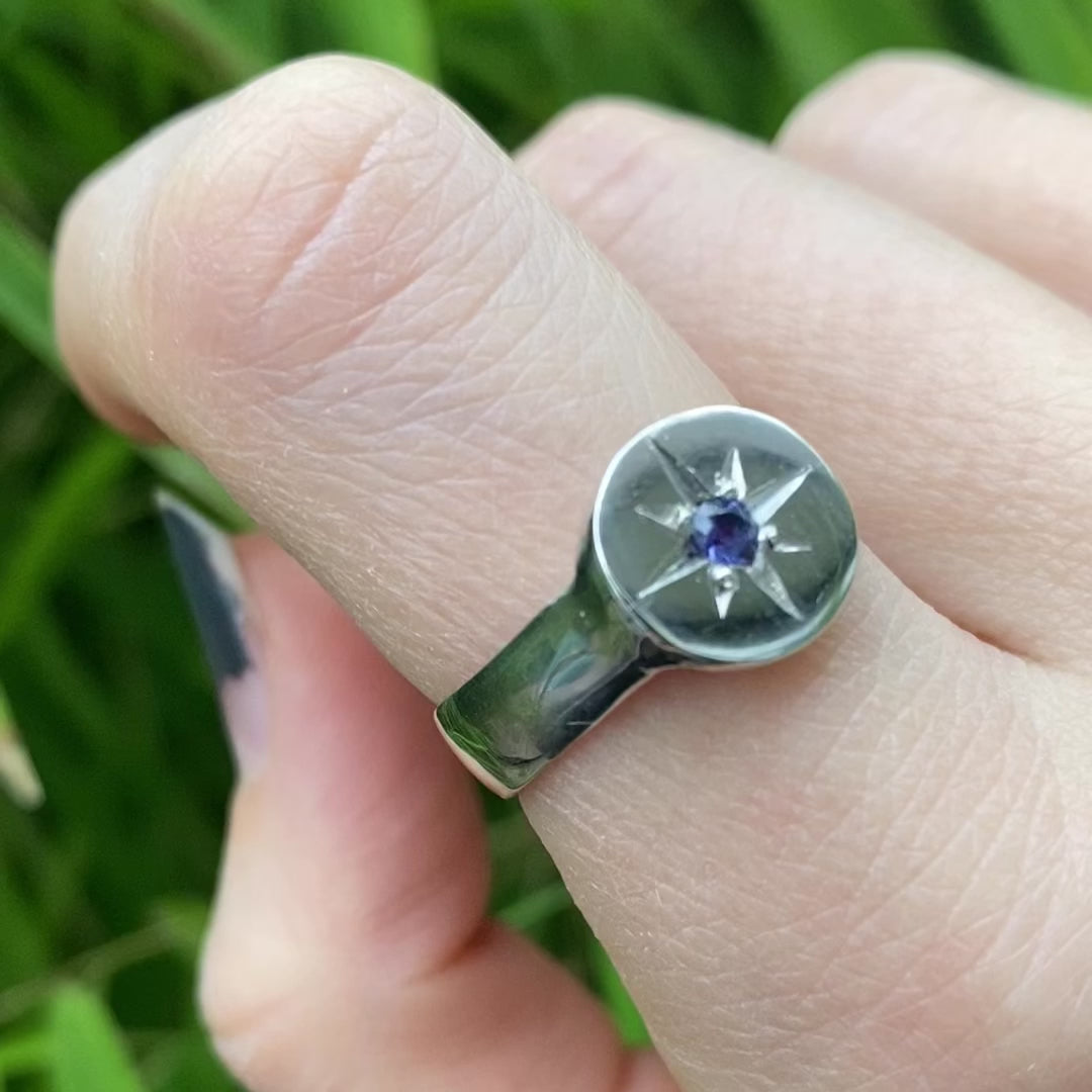 Silver signet ring with sapphire shown on hand